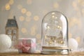 Beautiful snow globe and gift box on wooden table against blurred Christmas lights. Space for text Royalty Free Stock Photo