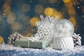 Beautiful snow globe, gift and decor on blue table against blurred Christmas lights