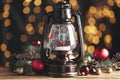 Beautiful snow globe in vintage lantern and Christmas decor on wooden table against blurred festive lights Royalty Free Stock Photo