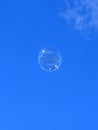 Beautiful soap bubble flies into the blue sky Royalty Free Stock Photo