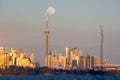 Beautiful soft pink colors at dusk with the full moon rising over the Toronto skyline and CN Tower