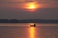 Beautiful soft sunset over a sea with a silhouette of a man fishing in a boat Royalty Free Stock Photo