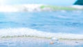 Beautiful soft waves with bubbles foams of blue water ocean sea and small shell on tropical sand beach blurred background Royalty Free Stock Photo