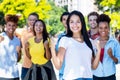 Beautiful south american female student with group of cheering young adults