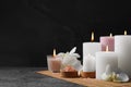 Beautiful spa composition with burning candles and flowers on dark grey table against black background. Space for text Royalty Free Stock Photo