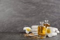 Beautiful spa composition with essential oil, stones and flowers on grey table. Space for text Royalty Free Stock Photo