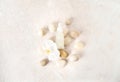 Beautiful spa composition of natural cosmetics with sea pebbles and white orchid flower on natural pink marble background. Flat Royalty Free Stock Photo