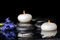 Beautiful spa concept of blooming iris flower, candles and black Royalty Free Stock Photo