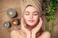 Beautiful spa woman with a towel on her head lying and touching face skin. Skincare Royalty Free Stock Photo