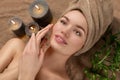 Beautiful spa woman with a towel on her head lying and touching face skin. Skincare. Beauty smiling model girl in spa salon Royalty Free Stock Photo