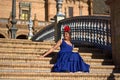 The woman in the blue flamenco dress sitting on the steps Royalty Free Stock Photo