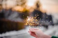 Beautiful sparklers in the hands of a girl on a city background, holiday and Christmas and New Year concept