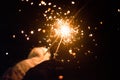 beautiful sparklers in woman hands on dark background