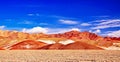 Beautiful spectacular desert landscape with red orange sandstone hills and mountains in contrast with blue summer sky - Salar de Royalty Free Stock Photo
