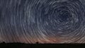 Beautiful Spiral Star Trails over filed with lonely tree. Beautiful night sky. Royalty Free Stock Photo