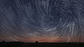 Beautiful Spiral Star Trails over filed with lonely tree.