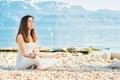 Beautiful spiritual woman meditating by the lake