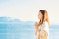 Beautiful spiritual woman meditating by the lake