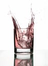 A beautiful splash of ice in a glass of pink water Royalty Free Stock Photo