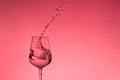 Beautiful splashes of water in a wine glass, with red filter, close up with copy space. Royalty Free Stock Photo