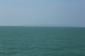 Beautiful split at the horizon panorama day shot of calm blue turquoise ocean water and blue sky with wild islands, hills and a Royalty Free Stock Photo