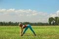 Beautiful sport woman doing stretching fitness exercise in city park at green grass. Royalty Free Stock Photo