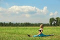 Beautiful sport woman doing stretching fitness exercise in city park at green grass. Royalty Free Stock Photo