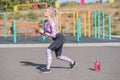 Beautiful and sportive blonde girl doing lunges on a street sports ground. Royalty Free Stock Photo