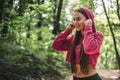 Beautiful sports female put oh headphones before her training outdoors.