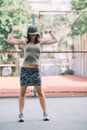 Beautiful sports girl in khaki clothes and a cap on the playground shows biceps and smiles. Healthy lifestyle.