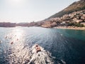 A beautiful sports wooden luxury boat with tourists floats against the sunset. A motor boat and kayaks with paddles