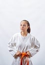 Beautiful sportswoman in karategi with an orange belt