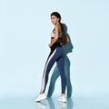 Beautiful sportswoman in sportswear working out doing stretching sports exercises on light blue Royalty Free Stock Photo