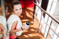 Beautiful sportswoman with white towel drinking water in gym Royalty Free Stock Photo