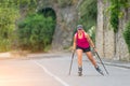 Beautiful sporty blonde girl with Rollerblade and climbing stick