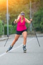 Beautiful sporty blonde girl with Rollerblade and climbing stick