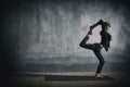 Beautiful sporty fit yogi woman practices yoga asana Natarajasana - Lord Of The Dance pose in the dark hall Royalty Free Stock Photo