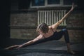 Beautiful sporty fit yogini woman practices yoga asana in the dark hall Royalty Free Stock Photo