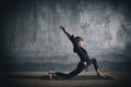 Beautiful sporty fit yogini woman practices yoga asana Virabhadrasana 1 - warrior pose 1 in the dark hall Royalty Free Stock Photo