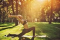 Beautiful young woman practices yoga asana Virabhadrasana 1 - warrior pose 1 in the park at sunset Royalty Free Stock Photo