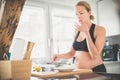 Beautiful sporty fit young pregnant woman preparing healthy meal in home kitchen. Healty lifestyle concept. Royalty Free Stock Photo
