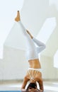 Beautiful sporty fit young woman working out indoors against white wall, making yoga exercises. Healthy lifestyle Royalty Free Stock Photo