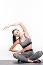 beautiful sporty girl exercising on yoga mat and smiling at camera Royalty Free Stock Photo