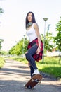 Beautiful girl skateboarder skateboarding in park