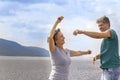Beautiful sporty mature couple dancing on the beach on the Volga river against the background of the Zhiguli mountains Royalty Free Stock Photo