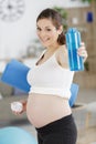 beautiful sporty pregnant woman drinking water during training