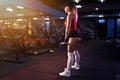 Beautiful sporty sexy woman in cap doing squat workout in gym Royalty Free Stock Photo