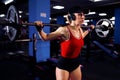 Beautiful sporty sexy woman in cap and headphones doing squat workout in gym Royalty Free Stock Photo