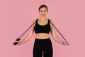 Beautiful sporty woman holding jump rope, ready to start her cardio workout Royalty Free Stock Photo