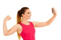 Beautiful sporty woman standing doing selfie with arm in fist over white background